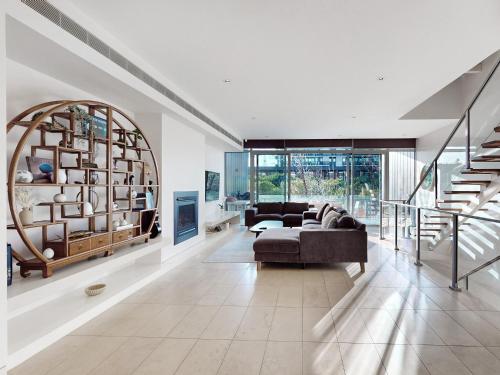 un soggiorno con un divano e una scala di Aerie Stays NewQuay Collection a Melbourne