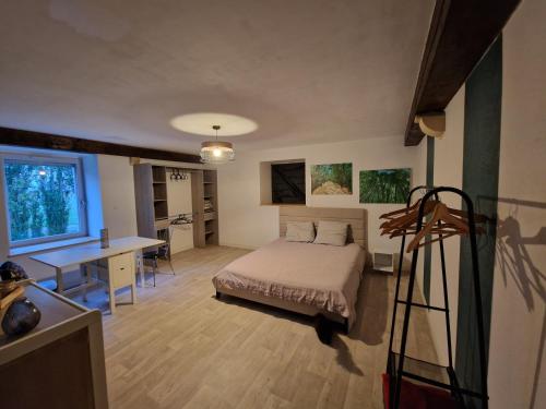 a bedroom with a bed and a desk at Appartement chez Sarah in Champdivers