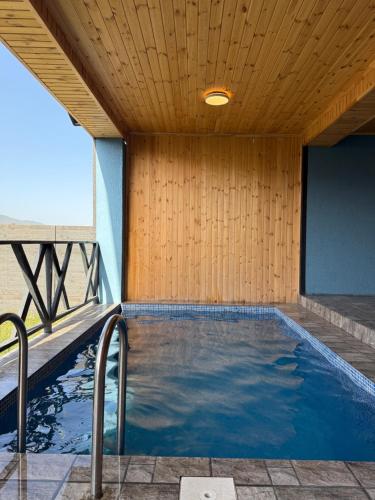 an indoor swimming pool with a wooden ceiling at Shahdag Berghoff House in Qusar