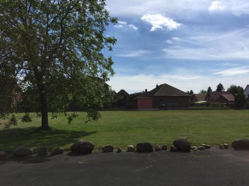 a park with a tree and a field with houses at Hotel Restaurant Körber in Osterwald Unterende