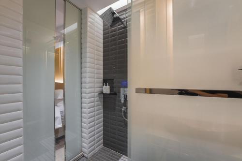 a bathroom with a shower with black tiles at Country Inn & Suite by Radisson, Shanghai Railway Station in Shanghai