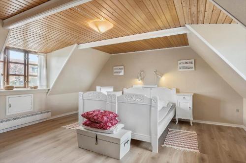 a attic room with two beds and a staircase at AE270-Soby-Aero-Lodsgyden-2 in Søby