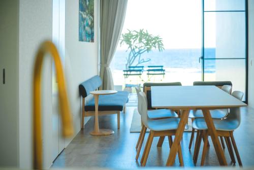 a dining room with a table and chairs and a window at BEYOND THE SEA amami in Tatsugo