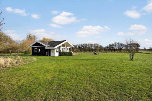 a small black and white house in a field at AE227-Soby-Aero-Lebymarksvej-3 in Leby