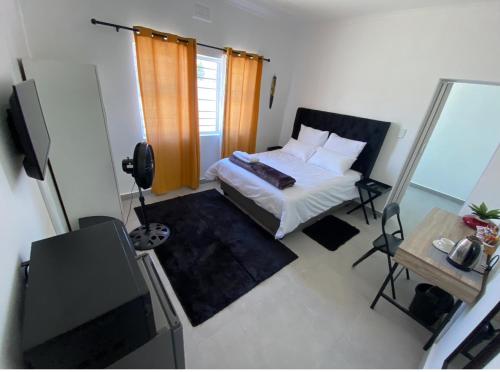 a small bedroom with a bed and a television at No 1 Guest house in Cape Town