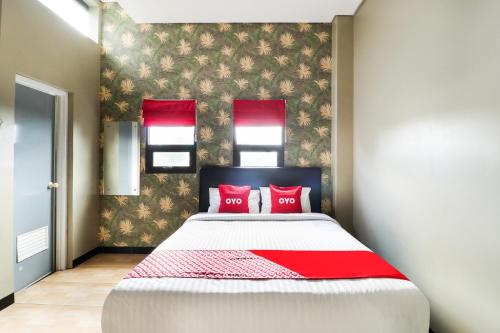 une chambre avec un grand lit avec des oreillers rouges dans l'établissement Hotel O Guest House Teras Waruga Syariah, à Bandung