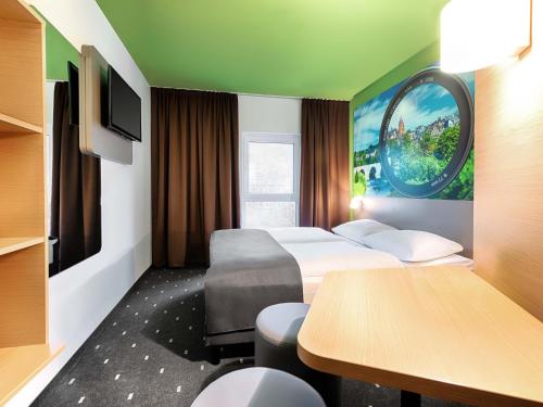 a hotel room with two beds and a table at B&B Hotel Wetzlar in Wetzlar