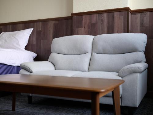 a living room with a couch and a coffee table at Tabist Centro Chita in Minamichita