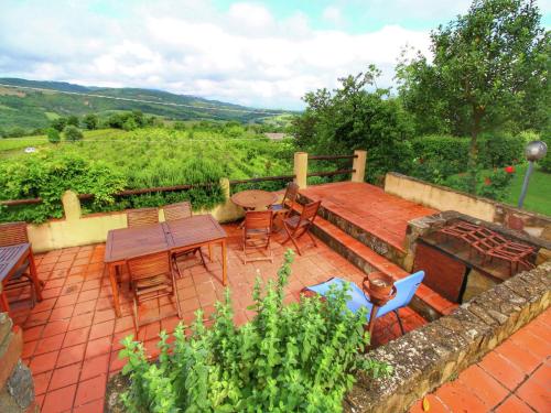 a patio with a table and chairs on a brick floor at Scenic Tuscan Farmhouse in San Quirico dʼOrcia