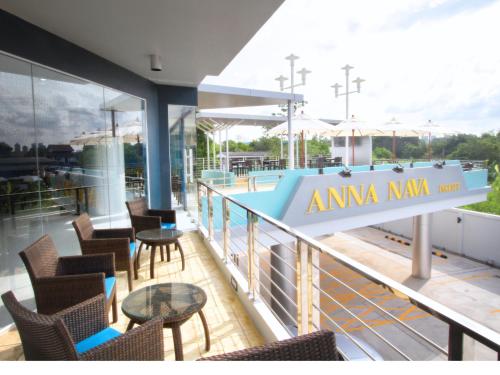 a balcony with chairs and tables and a swimming pool at Anna-Nava Pakkret Hotel in Nonthaburi