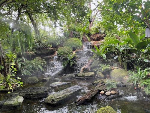 a waterfall in the middle of a garden at Anna-Nava Pakkret Hotel in Nonthaburi