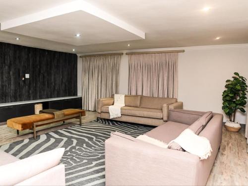 a living room with two couches and a rug at Sou House in Louis Trichardt