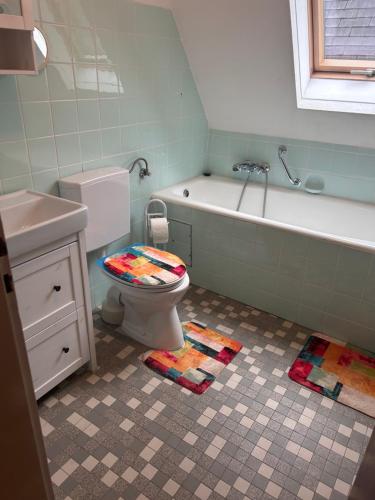 a bathroom with a toilet and a tub and a sink at Jacky Wohnung in Schonwald im Schwarzwald