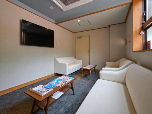a living room with a couch and a table at Tabist Centro Chita in Minamichita