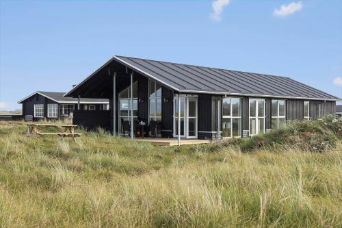 a black house on the side of a field at TV1515-Bindslev-Paradisdalen-23-B in Bindslev