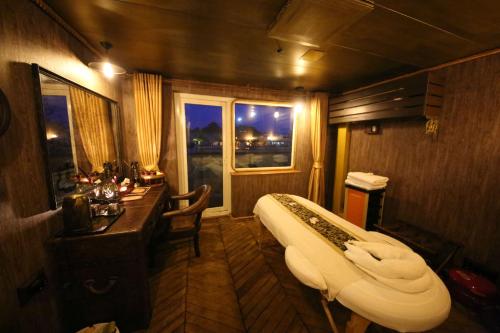 a room with a bed and a desk and a window at Vintage Luxury Yacht Hotel in Yangon