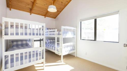 a room with three bunk beds and a window at Omaha's Shore Thing in Omaha