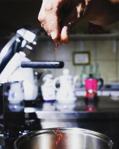 a person is stirring a pot of food at Cascina Il Convivio in Diano dʼAlba
