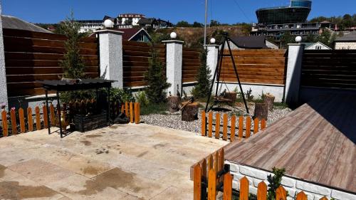 a backyard with a wooden fence and a table at A-frame evlər in Qusar