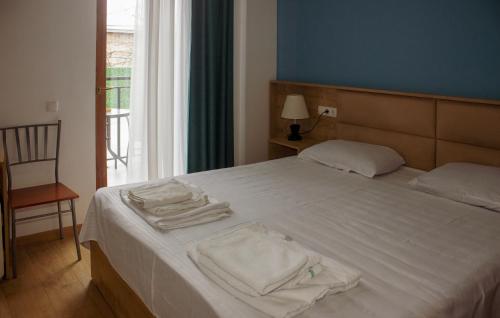 a bedroom with a white bed with towels on it at Hotel mia Telavi in Tʼelavi
