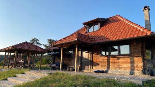 a wooden house with a red roof at Skroviste, Zlatibor-Vodice in Zlatibor