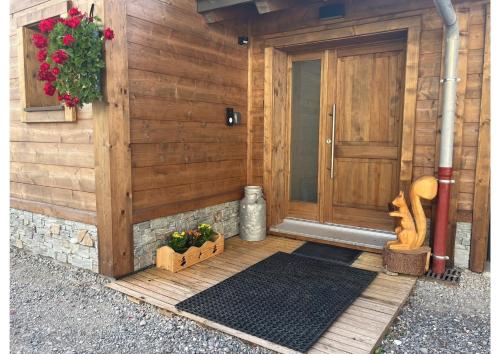 a front porch of a house with a door and flowers at Appartement LE 351 in Les Gets