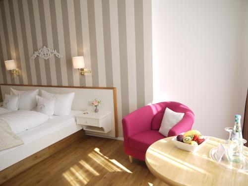a bedroom with a bed and a table and a chair at Hotel Ratsstuben in Lindau