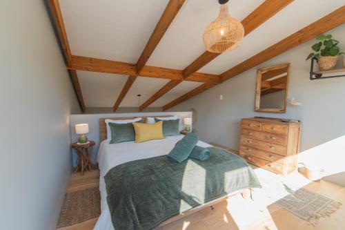 a bedroom with a bed and a wooden ceiling at Weaver's Nest Cottage - Nature Retreat! in Gqeberha