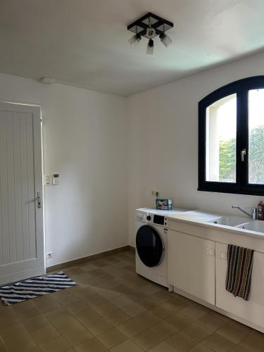 a laundry room with a sink and a washing machine at 282 - au petit baigneur in Challans