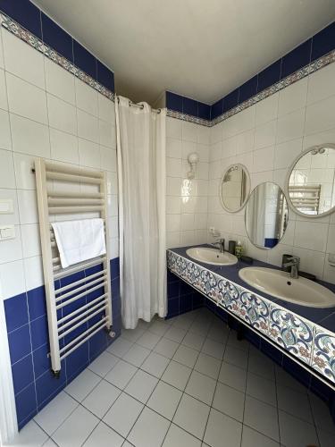 a blue and white bathroom with two sinks and a mirror at 282 - au petit baigneur in Challans