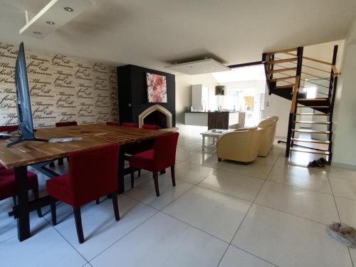 a dining room with a table and chairs and a fireplace at 229 - villa de la fosse a l ane in Le Fuilet