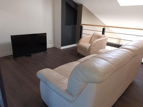 a living room with a white couch and a tv at 229 - villa de la fosse a l ane in Le Fuilet