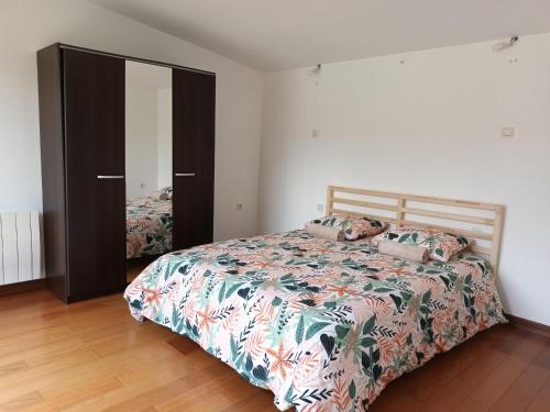 a bedroom with a bed and a closet with a bedspread at 229 - villa de la fosse a l ane in Le Fuilet