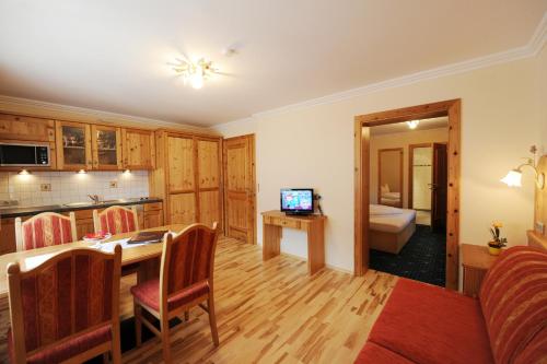 a living room with a kitchen and a dining room at Hotel Garni Landhaus Platzer in Zell am Ziller