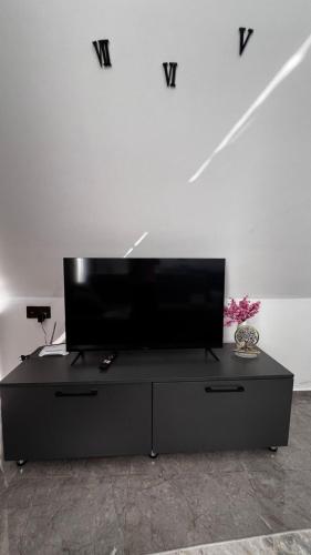 a flat screen tv sitting on top of a black entertainment center at A-frame evlər in Qusar