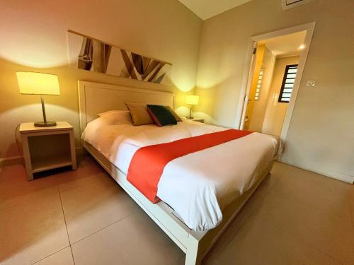 a bedroom with a large bed with a red blanket at Cozy Studio 2 in Trou aux Biches