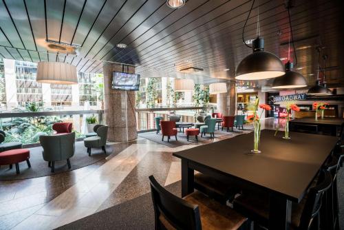 a lobby with a table and chairs and a bar at Scandic Infra City in Upplands-Väsby