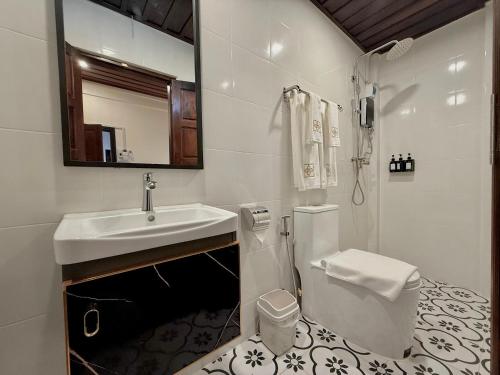 a white bathroom with a sink and a toilet at Onson De Boutique Hotel in Luang Prabang