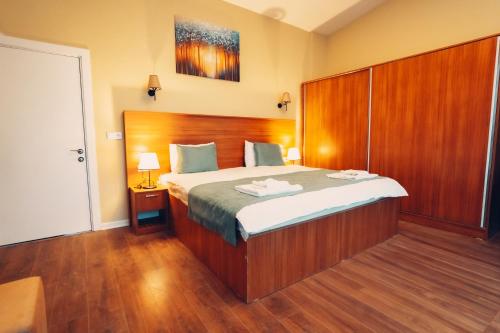 a bedroom with a large bed with a wooden headboard at Düzce Derdin Termal Resort & Spa in Duzce