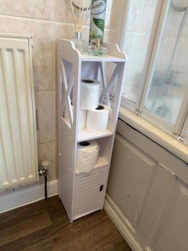 a white shelf with toilet paper on it next to a window at The RS Inn Cozy Homestay Premium Private Rooms With Parking Near Birmingham Airport, Lake Park For Solo, Couples & Family in Kingshurst