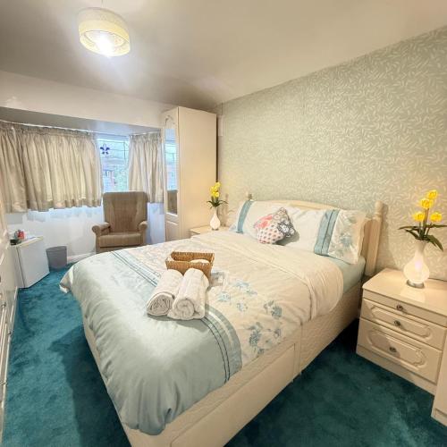 a bedroom with a large bed with towels on it at The RS Inn Cozy Homestay Premium Private Rooms With Parking Near Birmingham Airport, Lake Park For Solo, Couples & Family in Kingshurst