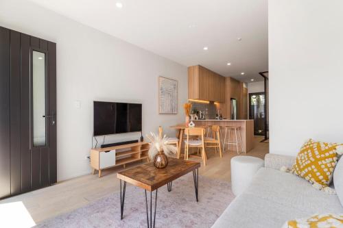 a living room with a couch and a table at The fern - Boutique Mount Albert Townhouse in Auckland