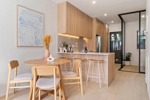 a kitchen with a round table and stools at The fern - Boutique Mount Albert Townhouse in Auckland
