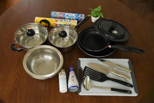a table topped with pots and pans and utensils at TUNAGU Base in Tsuruoka