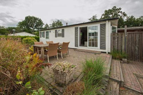 a small white house with a table and chairs at 42, Cottage - Oisterwijk - Nature in Oisterwijk