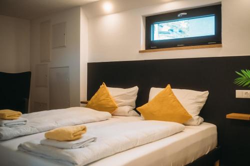 a bedroom with two beds with yellow pillows and a television at Ferienhaus Schöne Aussicht Schwarz in Edertal