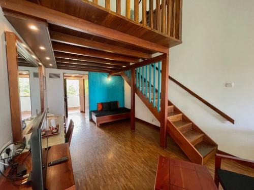 a room with a staircase and a living room at Tangerine Beach Hotel in Kalutara