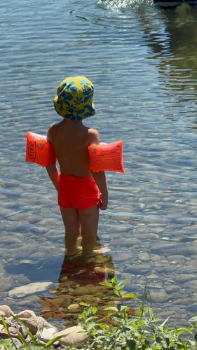 a young child standing in the water with a life raft at Vikendica Dani in Ljubovija