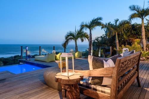a wooden deck with a bench and a view of the ocean at Nakai Beach Homestay in Trafalgar