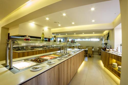 a restaurant with a buffet line with food at Porto Planos Beach Hotel in Tsilivi